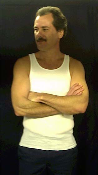Barry Newton, the Bearmonster, standing with crossed arms, looking to his right.